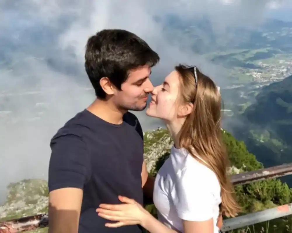 Dhruv Rathee with his wife Juli Lbr posing at a scenic mountain viewpoint.