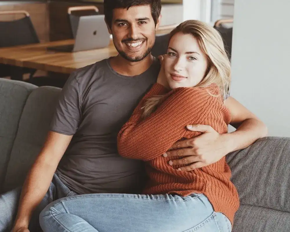 Dhruv Rathee embracing his wife Juli Lbr in a cozy home setting.