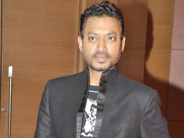 Irrfan Khan in a formal black blazer, photographed against a wooden background.