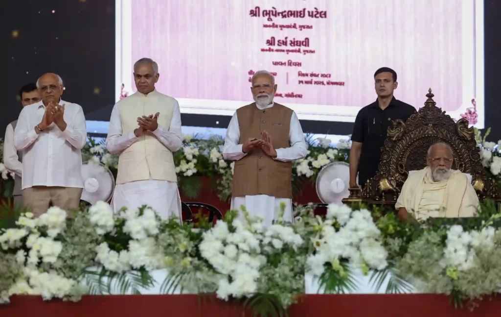 Narendra Modi standing at a ceremonial event with dignitaries and national flags