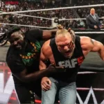 WWE Raw action shot showing a wrestler in black gear holding another wrestler near the ringside area during a chaotic match in front of a live crowd.