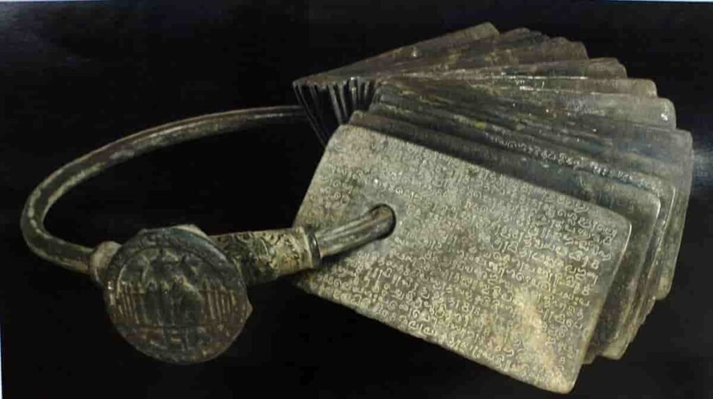 Historic Anaimangalam copper plates from the Chola era, shown as a set of inscribed copper sheets tied together with a ring.