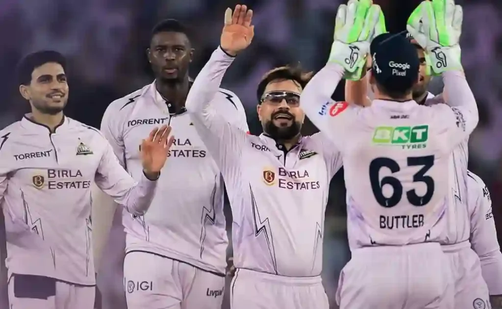 Gujarat Titans players celebrating a wicket during an IPL match.
