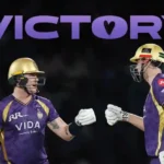 Two Kolkata Knight Riders players celebrate after a win with a fist bump.