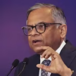 N. Chandrasekaran speaking at a podium in a dark suit and tie, delivering a keynote address.