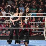 WWE women’s superstars Rhea Ripley, Charlotte Flair, Alexa Bliss, Jacy Jayne, Fallon Henley, and Lainey Reid stand in the ring during a SmackDown segment.