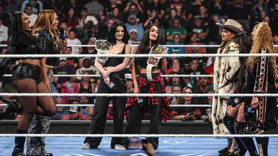 WWE women’s superstars Rhea Ripley, Charlotte Flair, Alexa Bliss, Jacy Jayne, Fallon Henley, and Lainey Reid stand in the ring during a SmackDown segment.