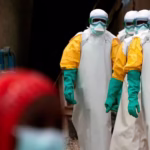 Health workers in full protective gear walking at an Ebola treatment centre in Beni, Congo.