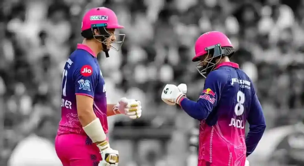 Two Rajasthan Royals batsmen exchange a fist bump on the pitch at Wankhede Stadium during the RR vs MI IPL 2026 match; crowd blurred in background.