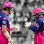 Two Rajasthan Royals batsmen exchange a fist bump on the pitch at Wankhede Stadium during the RR vs MI IPL 2026 match; crowd blurred in background.
